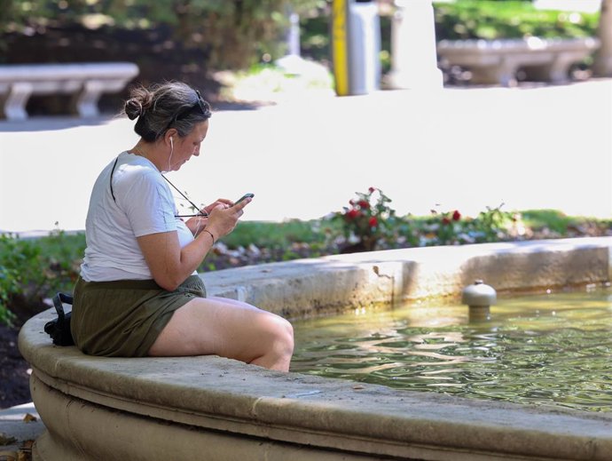 Una mujer con los pies metidos en una fuente durante una segunda ola de calor, a 23 de julio de 2024, en Madrid (España). Una segunda ola de calor llega hoy a la Península y afecta a gran parte del país hasta el jueves, con temperaturas que superan los 