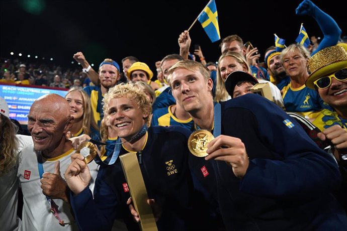 10 August 2024, France, Paris: Sweden's David Ahman (L) and Jonatan Hellvig celebrate wining gold after the men's gold medal beach volleyball match between Sweden and Germany at the Eiffel Tower Stadium, as part of the Paris 2024 Olympic Games. Photo: Sin