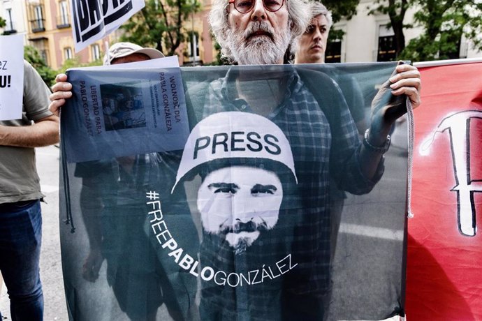 Archivo - Un hombre con un pañuelo con la cara de Pablo González durante una concentración por la liberación del periodista Pablo González, ante el consulado de Polonia en Madrid, a 26 de junio de 2024, en Madrid (España). 