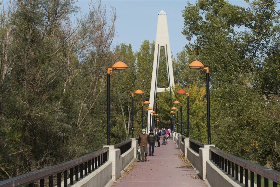 Archivo - Transeúntes caminan por la Pasarela del Ebro 