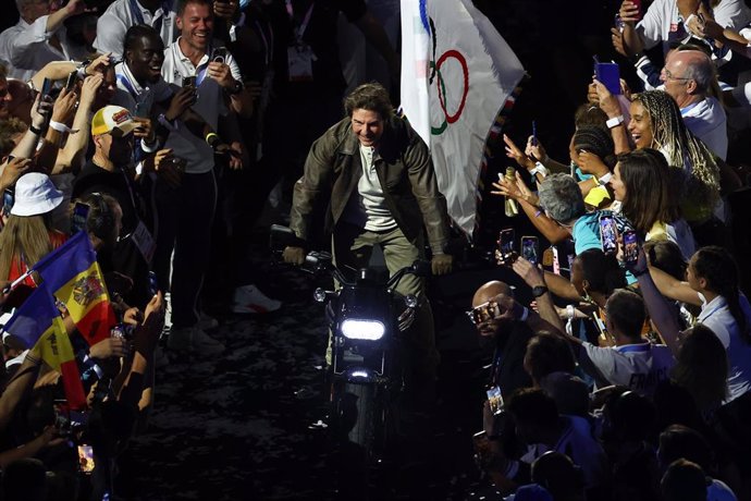 11 August 2024, France, Paris: US actor Tom Cruise rides past the athletes on a motorcycle during the closing ceremony of the Paris 2024 Olympic Games. Photo: Jan Woitas/dpa