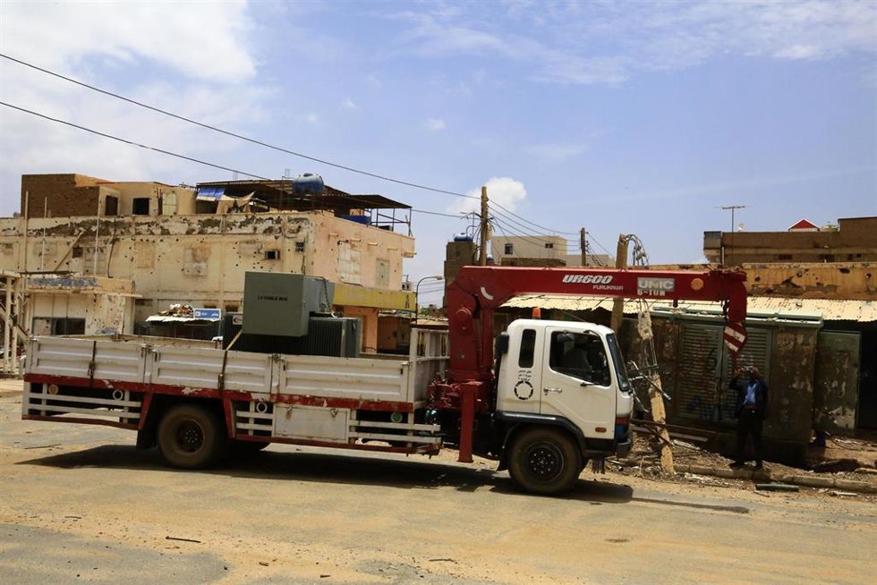 Trabajadores de electricidad cambian un transformador en una zona residencial de la ciudad de Omdurman, Sudán
