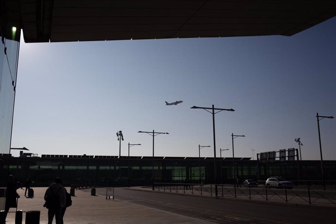 Archivo - Un avión sobrevuela el Aeropuerto de Barcelona