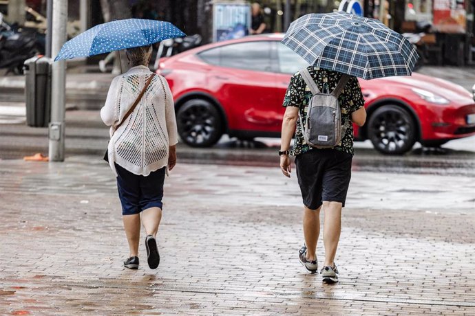 Archivo - Dos personas caminan bajo la lluvia, a 2 de septiembre de 2023, en Madrid (España).