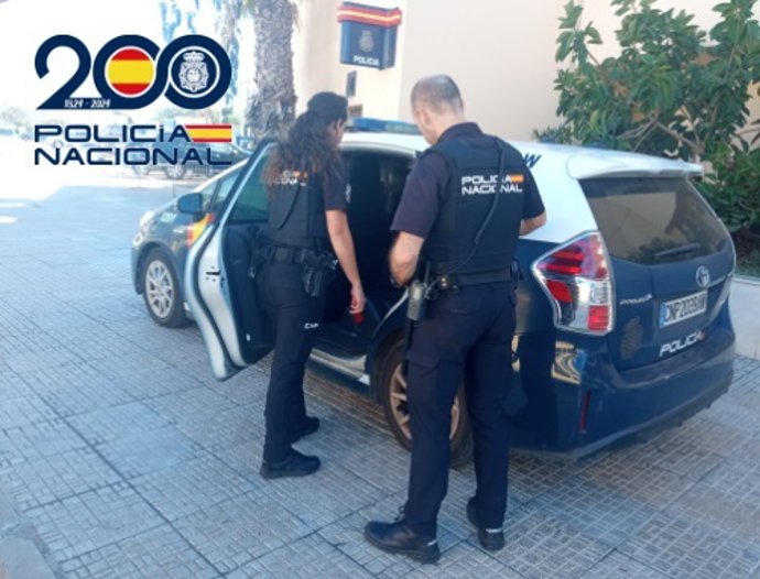 Imagen de archivo de unos agentes y un coche patrulla de la Policía Nacional en Melilla.