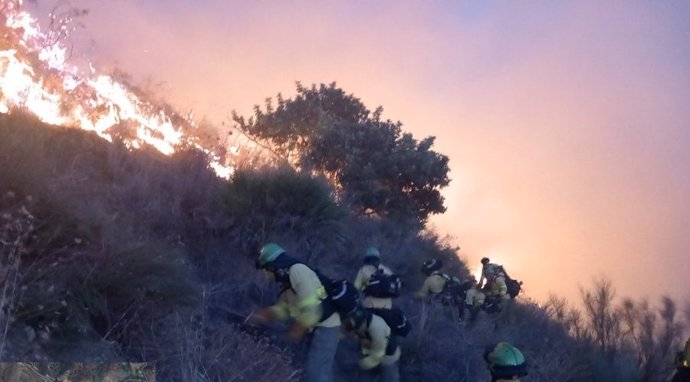 Bomberos del Plan Infoca trabajaban este pasado martes para sofocar las llamas en las escarpadas laderas de Peña Escrita, en Almuñécar (Granada)