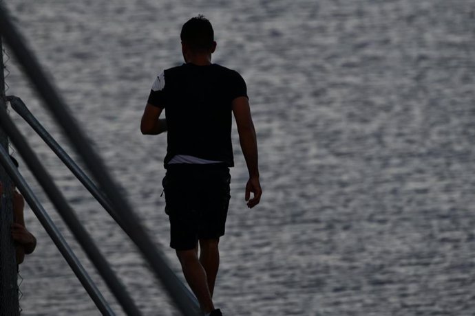 Archivo - Una persona migrante camina por la playa del Tarajal, imagen de archivo. 