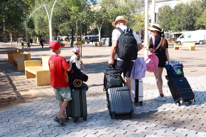 Turistas con maletas en la Alameda de Hércules de Sevilla. A 7 de agosto de 2024, en Sevilla (Andalucía, España).