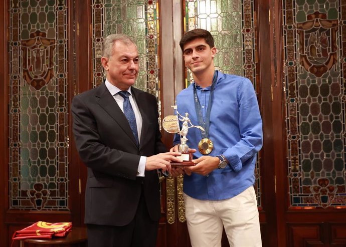 El alcalde de Sevilla, José Luis Sanz, hace entrega del giraldillo de la ciudad al futbolista Juanlu Sánchez, con su medalla de oro olímpica al cuello.