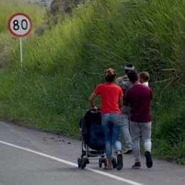 Archivo - Una familia de migrantes cruza una carretera en Colombia