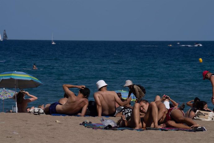 Varias personas en la playa en julio