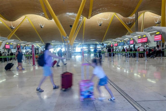 Una mujer y una niña caminan con sus maletas, con motivo de la operación salida del puente de agosto, en la T4, en el aeropuerto Adolfo Suárez Madrid-Barajas, a 14 de agosto de 2024, en Madrid (España).