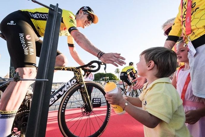 El ciclista estadounidense Sepp Kuss saluda a un niño durante la presentación oficial de La Vuelta 2024 en Lisboa