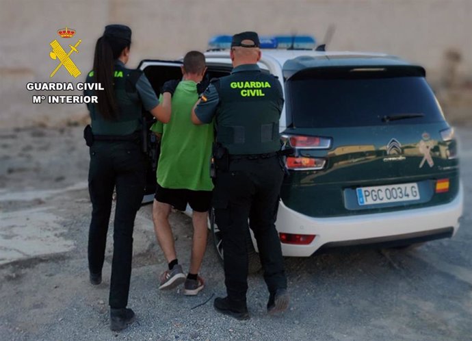 Dos agentes de la Guardia Civil trasladan al detenido