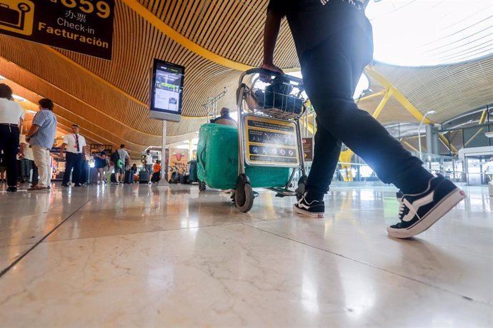 Varias personas junto a sus maletas con motivo de la operación salida del puente de agosto, en la T4, en el aeropuerto Adolfo Suárez Madrid-Barajas, a 14 de agosto de 2024, en Madrid (España). 