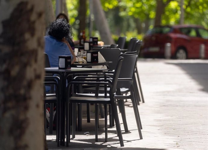 Archivo - Varias personas sentadas en una terraza