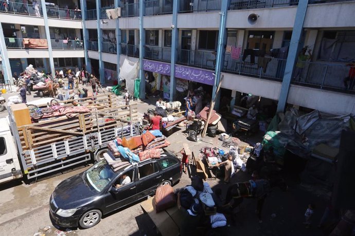 Palestinos cogen sus pertenencias para huir de Deir el Balá, en la Franja de Gaza