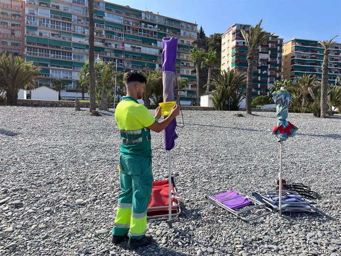 Archivo - Imagen de archivo de un operario de Playas señalizando sombrillas en agosto de 2023