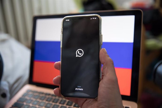 Archivo - Teléfono con la aplicación WhatsApp y una bandera de Rusia