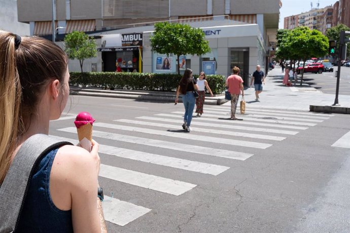 Archivo - Una mujer camina con un helado un día de verano en Badajoz. Imagen de archivo