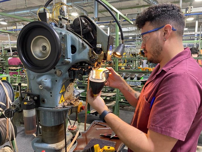 Archivo - Un joven trabajador dentro de una fábrica de calzado.