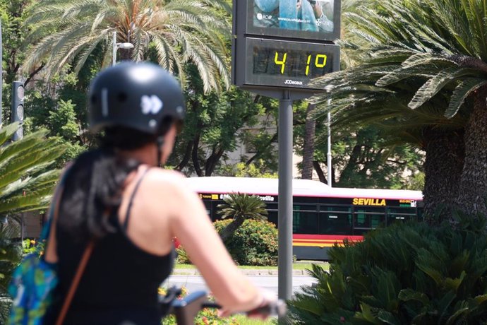 Una joven se resguarda del sol con un abanico para soportar las altas temperaturas. A 10 de agosto de 2024, en Sevilla (Andalucía, España).