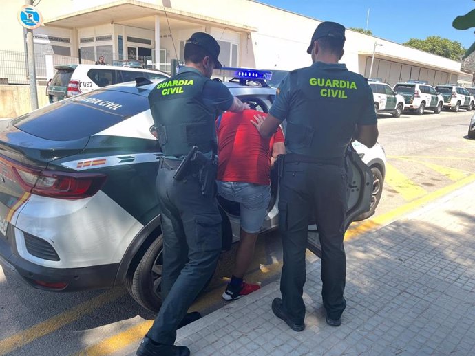 Agentes de la Guardia Civil conduciendo a uno de los arrestados.