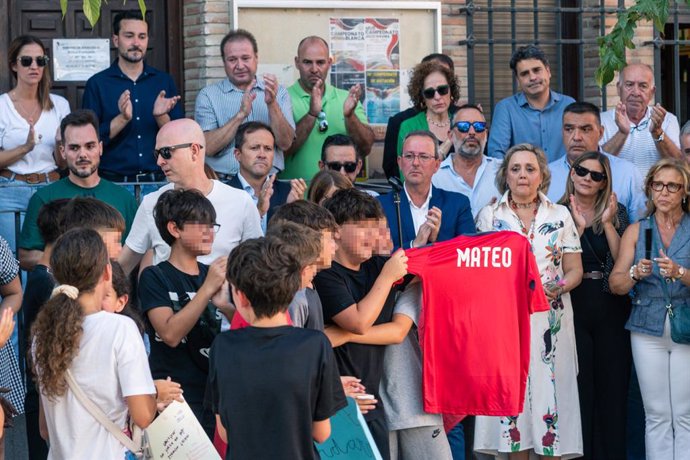 Amigos del niño asesinado muestran una camiseta con su nombre, durante el minuto de silencio por el asesinato de un menor, en la puerta del Ayuntamiento de Mocejón, a 18 de agosto de 2024, en Mocejón, Toledo, Castilla-La Mancha (España). 