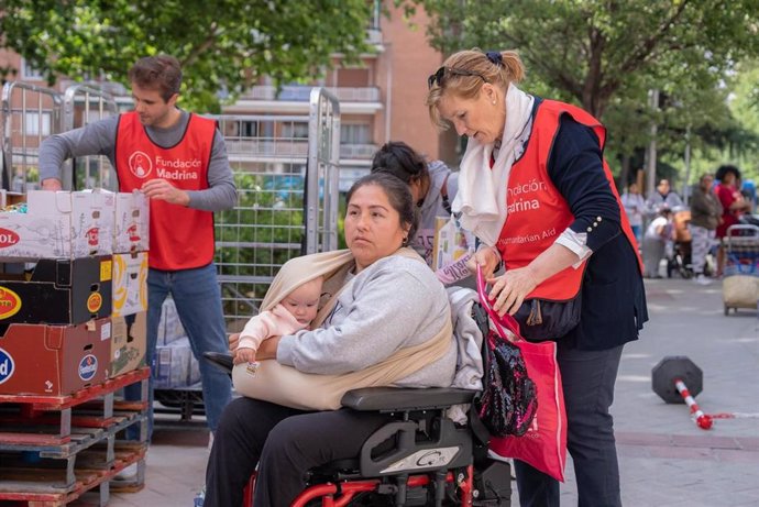 Voluntarios de la Fundación Madrina ayudando a una madre.