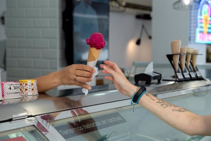 Archivo - Una mujer compra un helado 