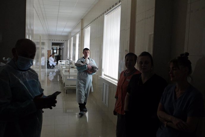 Archivo - 08 March 2022, Ukraine, Kiev: A man carries a newborn baby down the corridor of a maternity hospital functioning under martial law due to the Russian invasion. Photo: -/Ukrinform/dpa