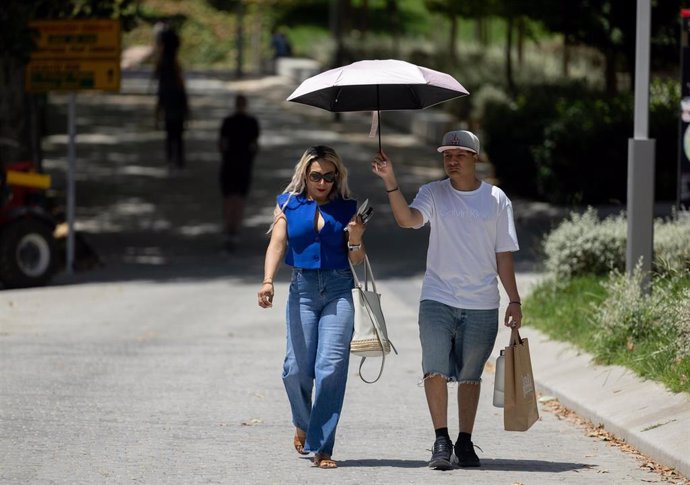 Dos personas se protegen del sol.