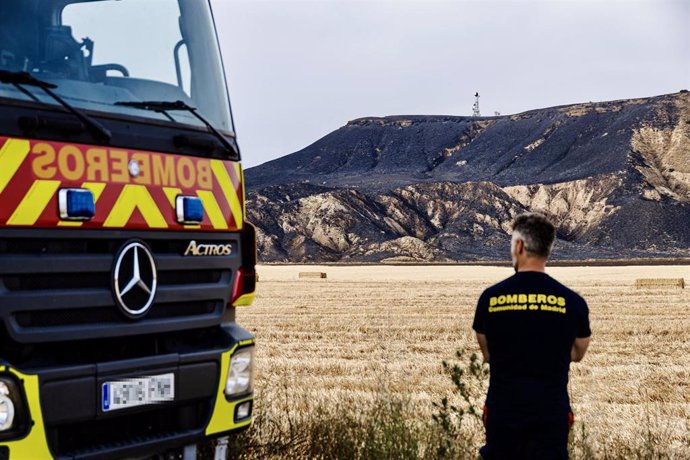 Archivo - Bombero vigila zona quemada tras un incendio. Archivo.