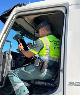 Un guardia civil analiza la tarjeta de un tacógrafo.