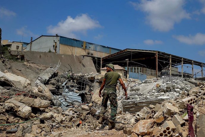 Un miliciano de Hezbolá entre los escombros dejados por un ataque israelí en Kfour, Líbano.