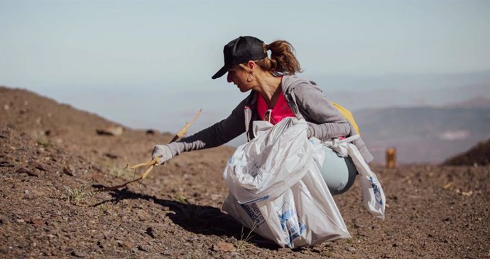 Archivo - Una voluntaria participa en una jornada de limpieza en Sierra Nevada, en imagen de archivo