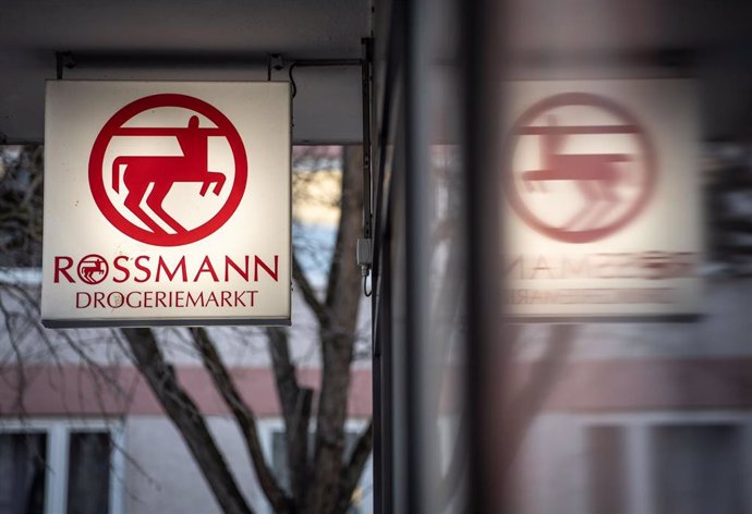 Archivo - FILED - 09 March 2022, Rheinland-Pfalz, Mainz: An illuminated sign with the company logo hangs on a branch of the Rossmann drugstore chain in Mainz city center. German drugstore chain Rossmann has announced plans to invest more money in its stor