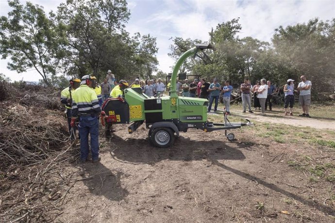 Vecinos de Ortigosa del Monte asisten a una explicación de cómo se fragmentan los residuos de poda, para su compostado.