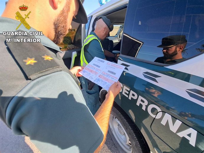 Agente de la Guardia Civil consultando documentación de un transporte de uva del Marco de Jerez. ARCHIVO.