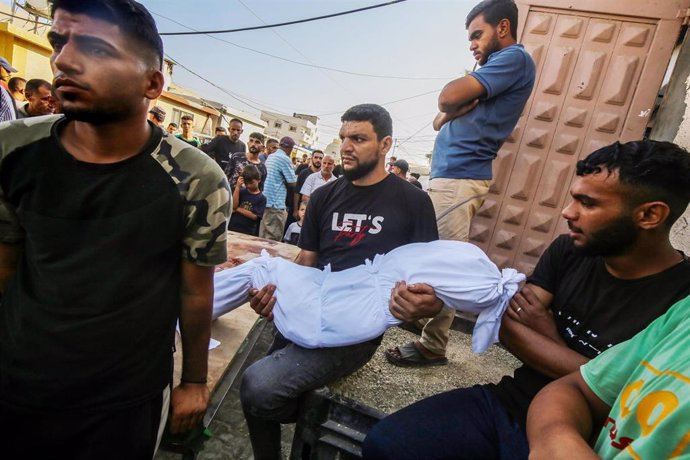 Un palestino porta el cadaver de un familiar muerto por los ataques de Israel sobre Gaza.