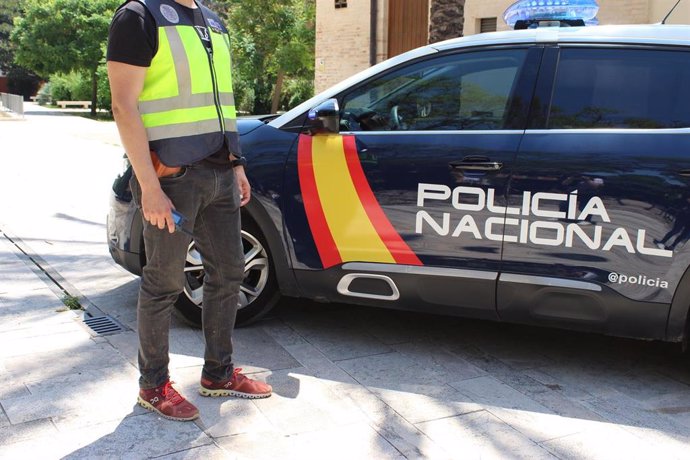 Agente y vehículo de la Policía Nacional.