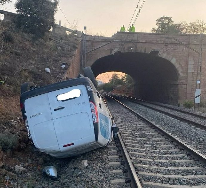 Imagen de la furgoneta volcada en las vías del tren