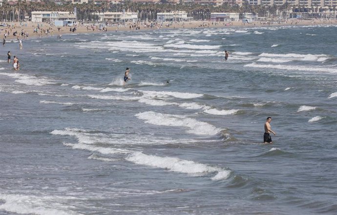 Archivo - Varias personas se bañan en la playa de la Malvarrosa