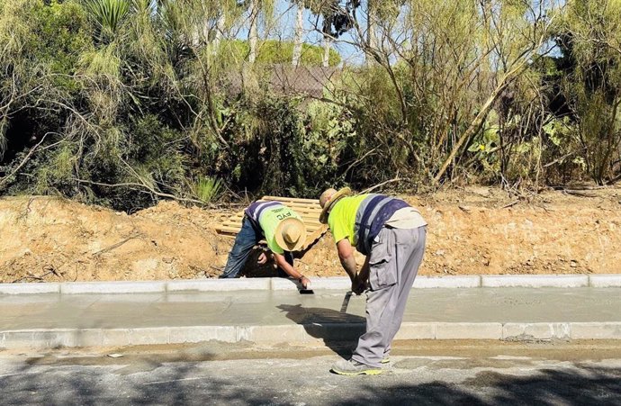 Operarios del Ayuntamiento de El Puerto trabajan en el acerado de la avenida de La Libertad.