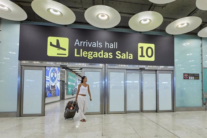 Archivo - Un a viajera salen con sus maletas en la sala 10 de llegadas de la Terminal 4 del Aeropuerto Adolfo Suárez Madrid-Barajas, a 1 de agosto de 2023, en Madrid (España).  