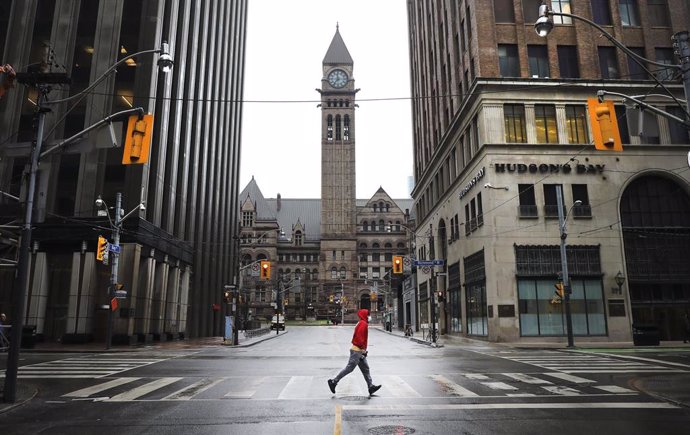 Archivo - 13 April 2020, Canada, Toronto: A man runs across an empty intersection of Bay street and Richmond amid restrictions on public life and non-esseential activities to curb the spreading of coronavirus. Photo: Richard Lautens/The Toronto Star via Z