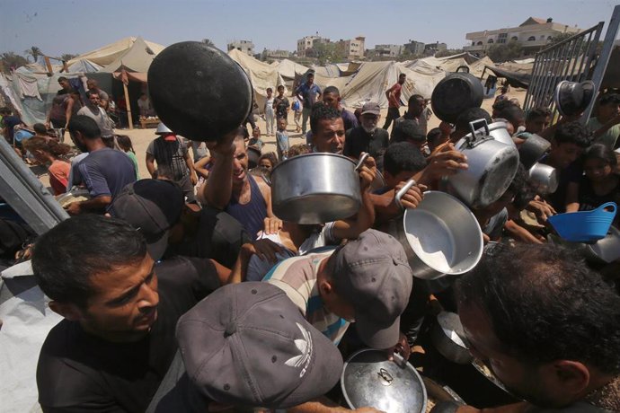 Palestinos desplazados en la Franja de Gaza se agolpan para recibir ayuda en Deir el Balá