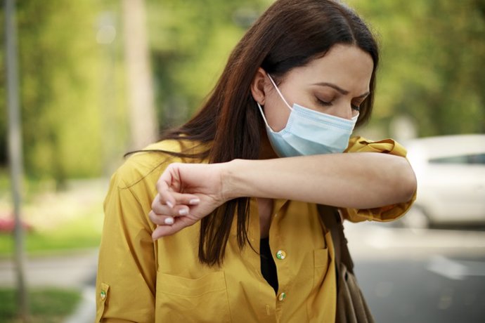 Archivo - Mujer estornudando con mascarillla. Alergia. Primavera