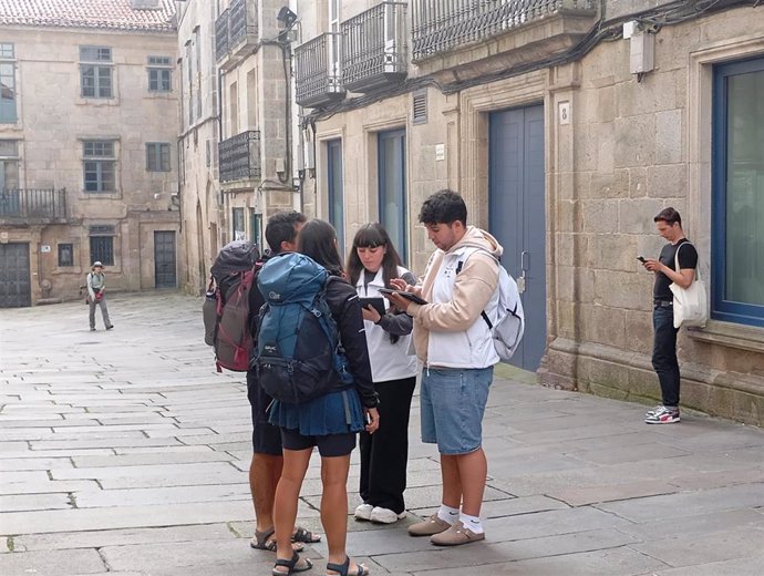 Una pareja de informadores son dos peregrinos cerca de la Praza de Cervantes.