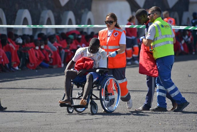 Archivo - Los servicios sanitarios atienden a los migrantes a la llegada de una patera al muelle de La Restinga 